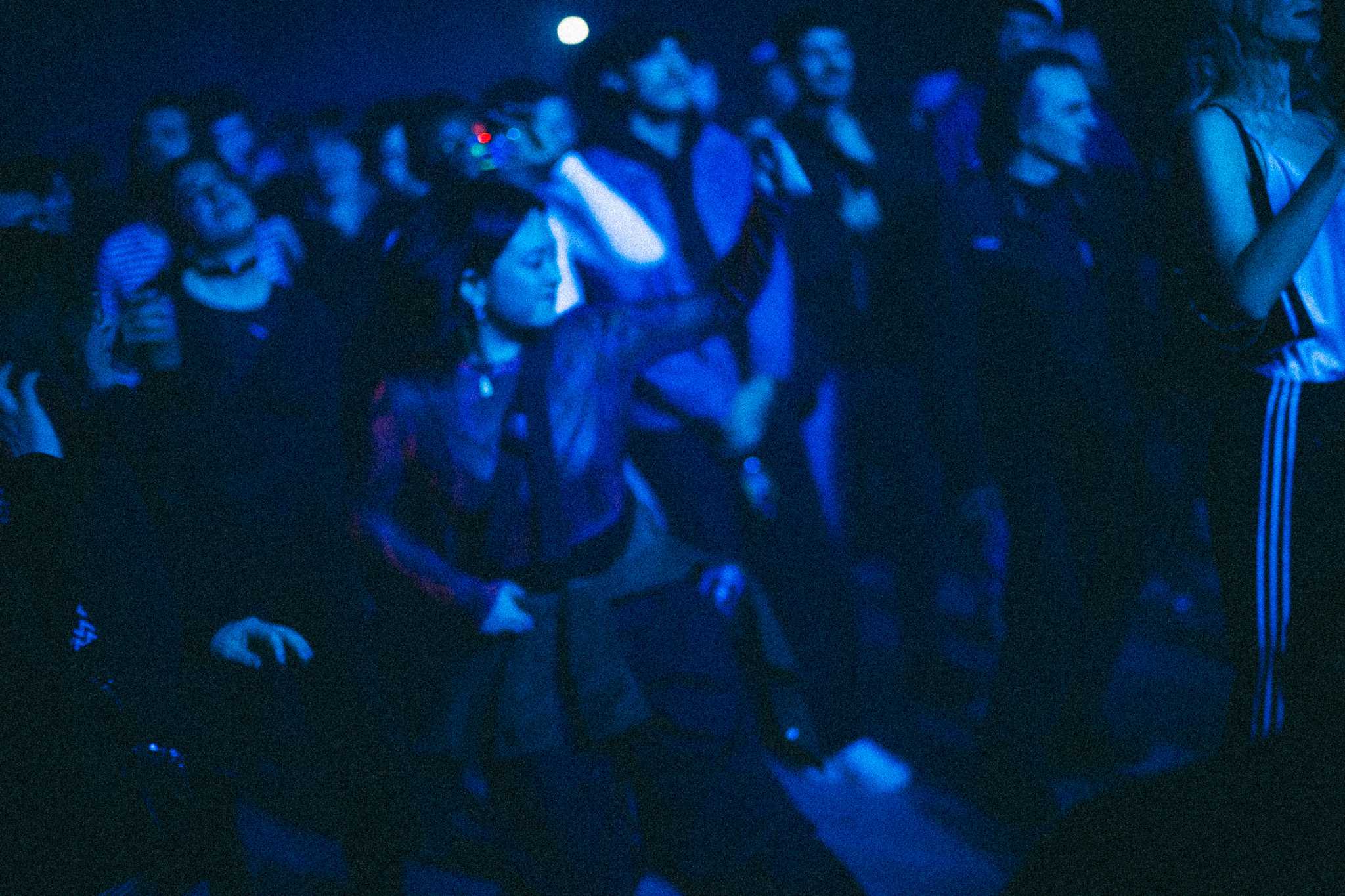 The crowd in blue light, dancing close together