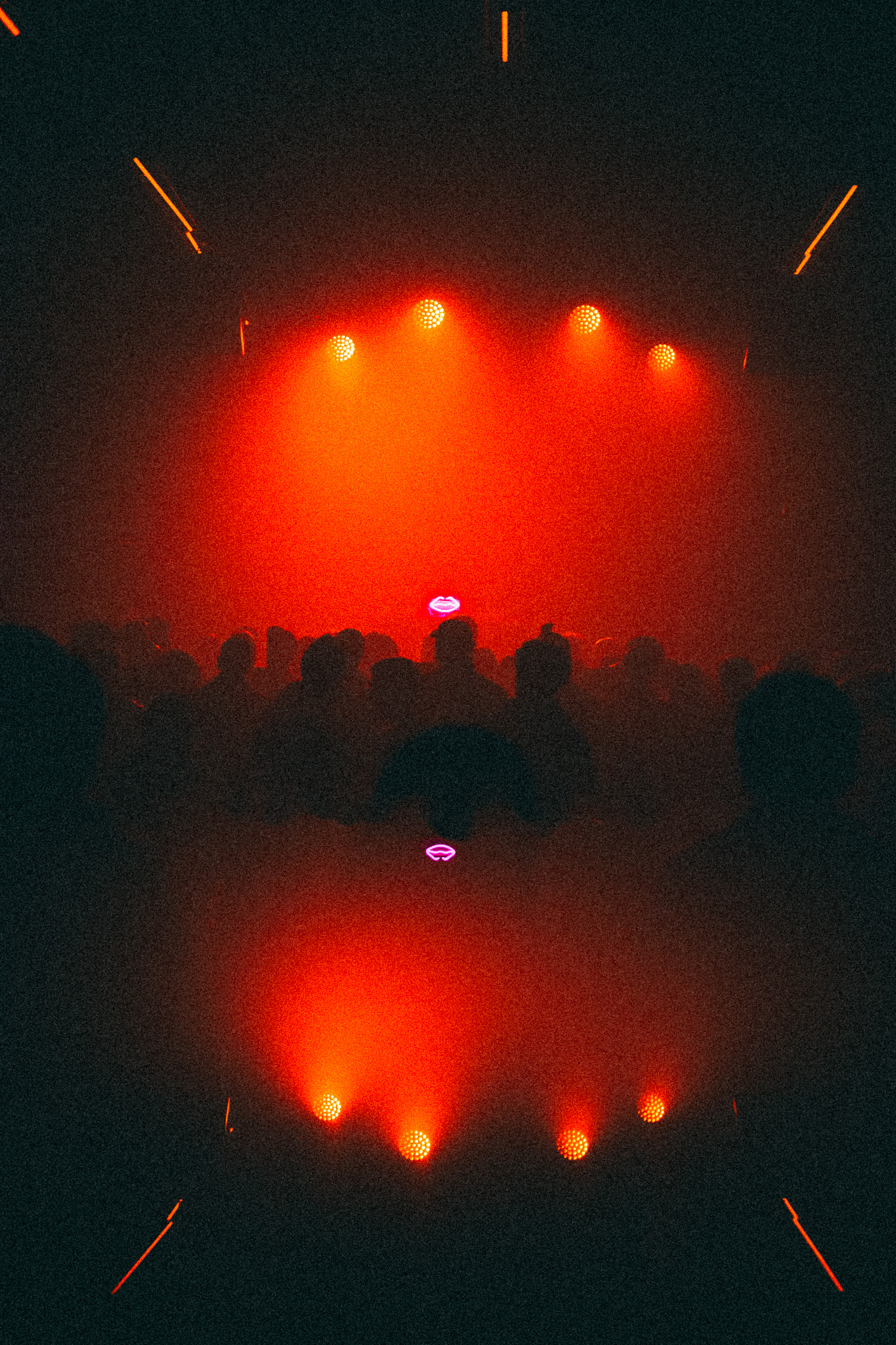 Red beams over the crowd, the arrangement almost symmetrical, reflected below